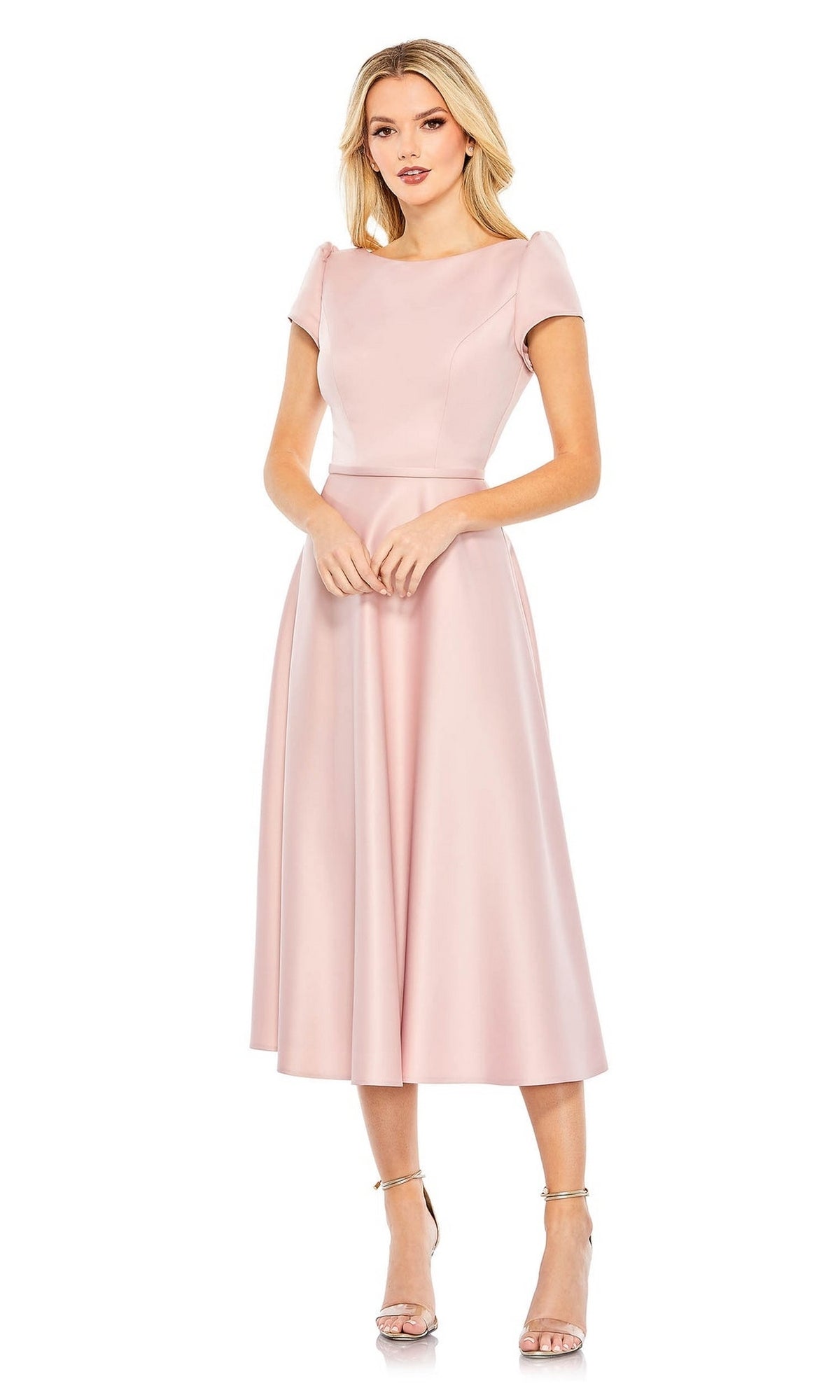 A woman wears the Short Wedding Guest Dress 26663 by Mac Duggal, which features cap sleeves and a full, A-line knee-length skirt. She pairs it with strappy high-heeled sandals against a white background.